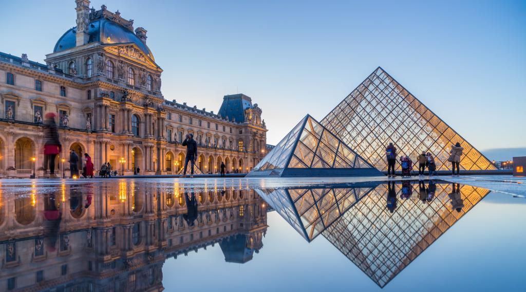  View of famous Louvre Museum with Louvre Pyramid at evening at sunset in Paris France 